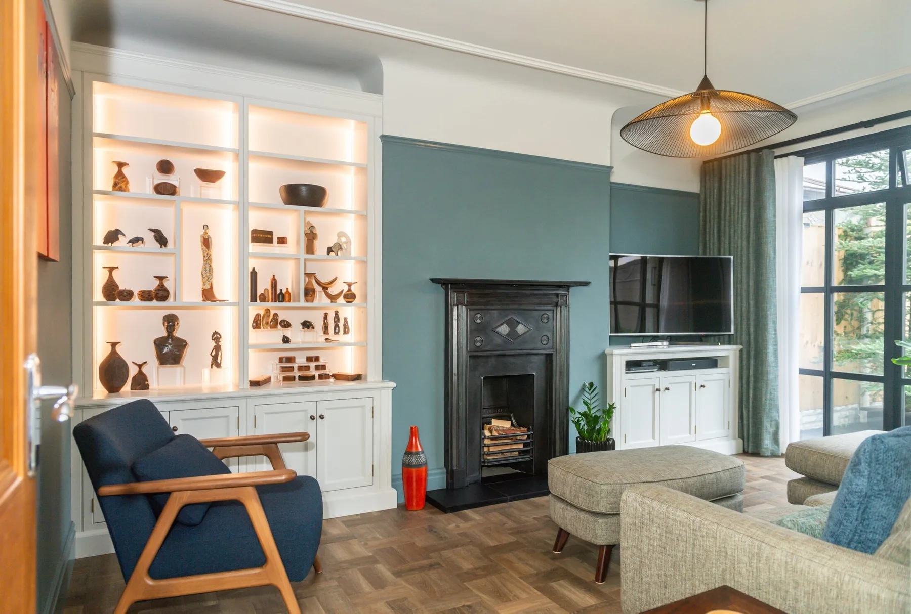 An interior with illuminated fitted display cabinetry