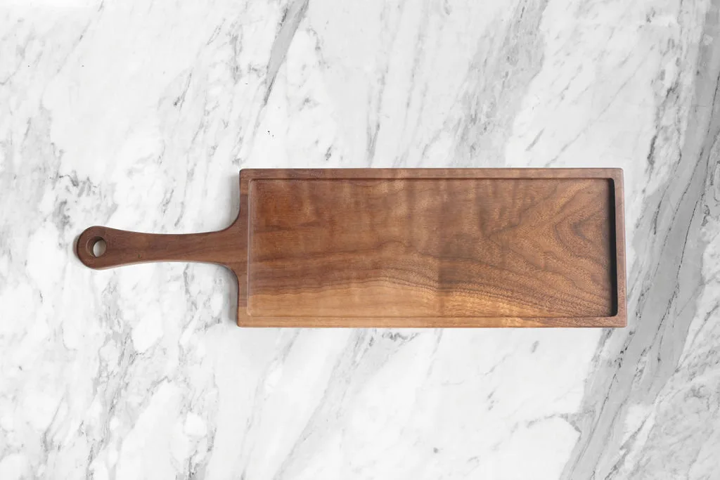 A solid walnut serving board by Shakespeare and Taylor