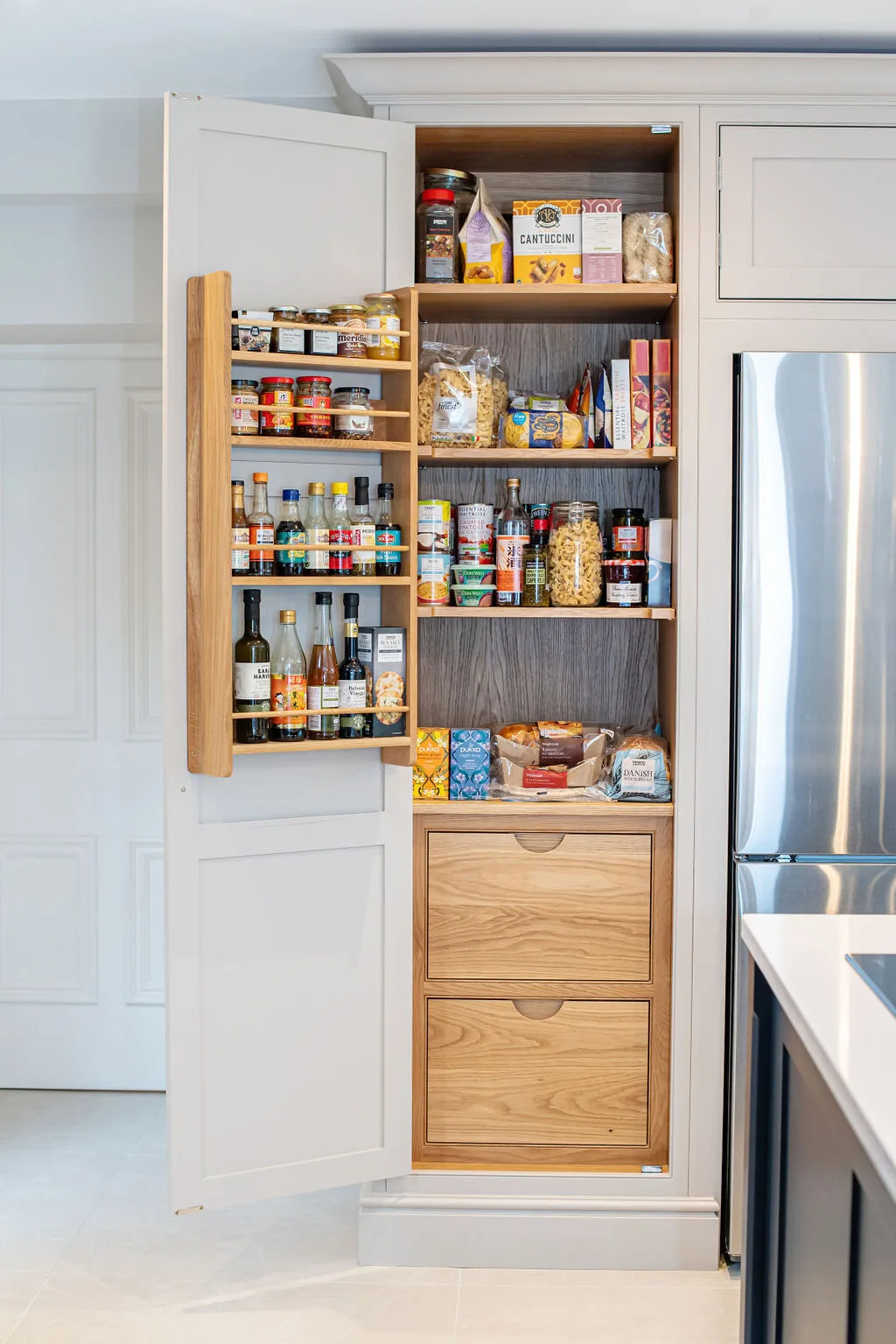 An integrated oak pantry and wine cabinet within a kitchen